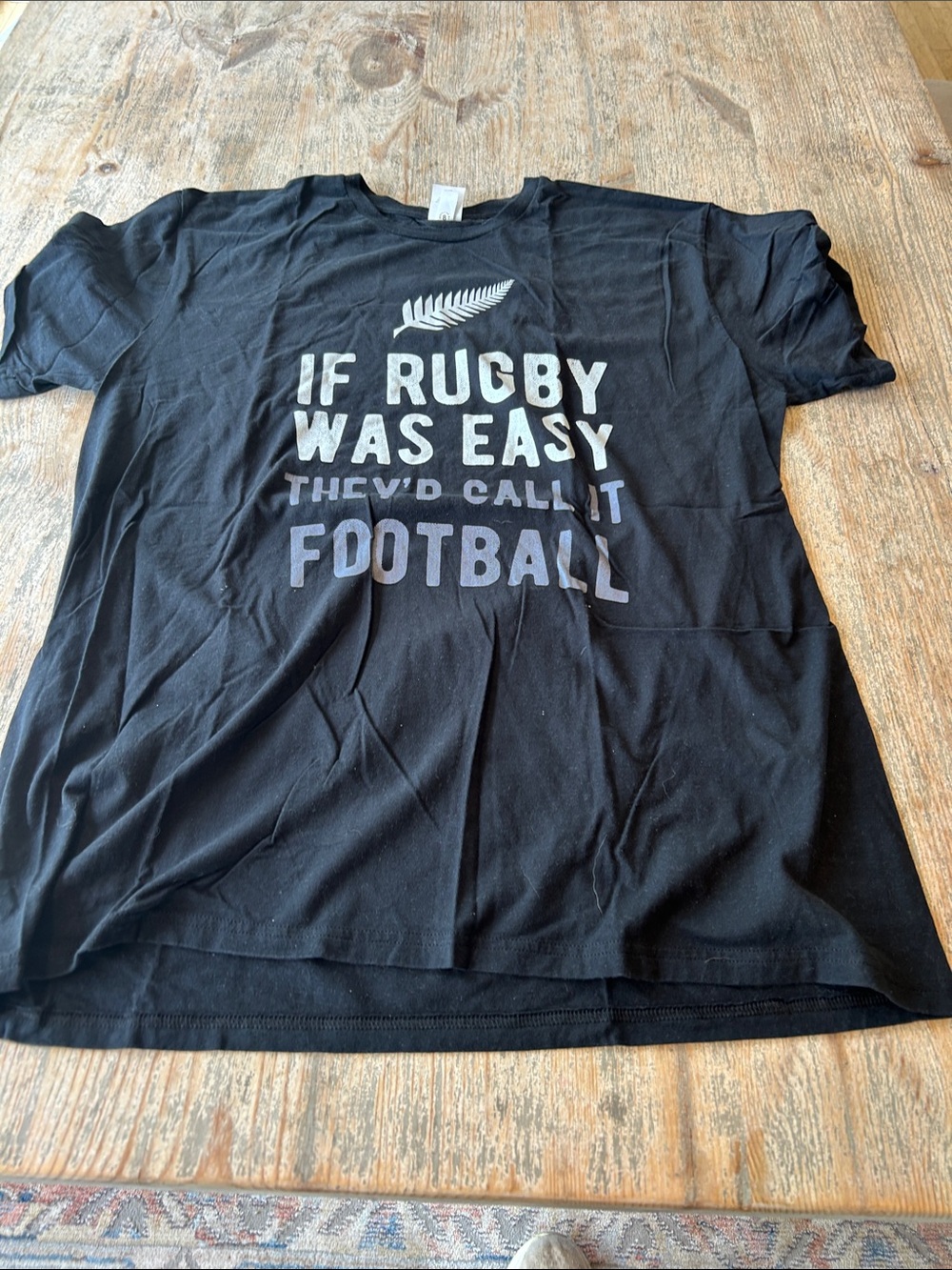 Source Unknown Black Tee with Light Gray Rugby Slogan